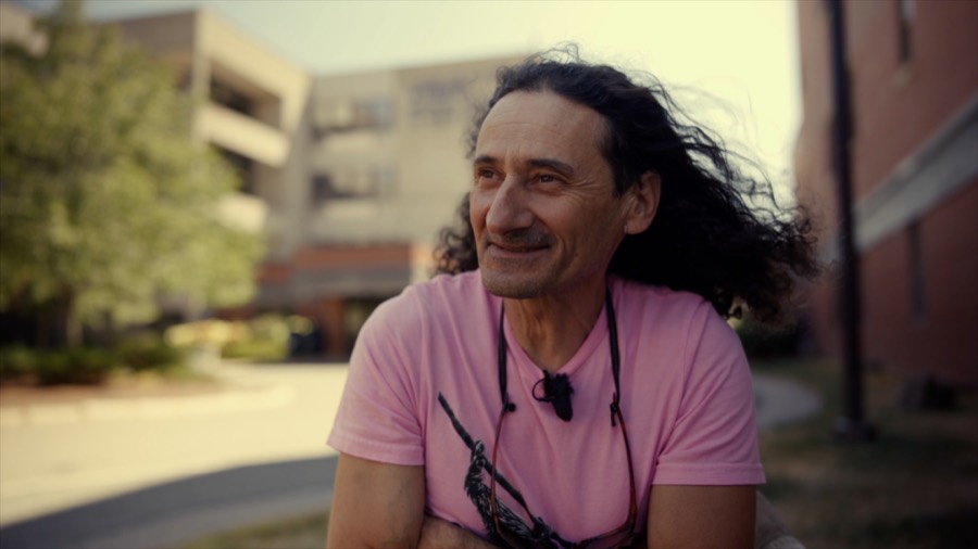 Andrea outside the hospital where he recovered. Film still.