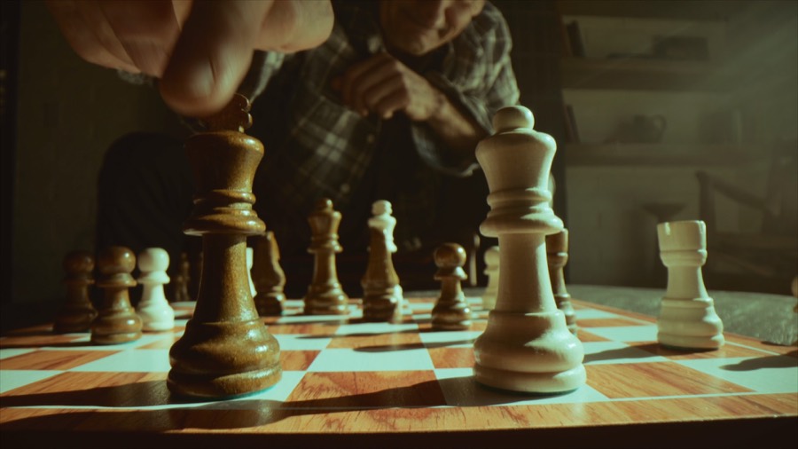 Andrea's hand on a pawn mid-game. Film still.