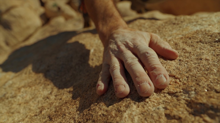 Andrea's hand pressed to granite. Film still.