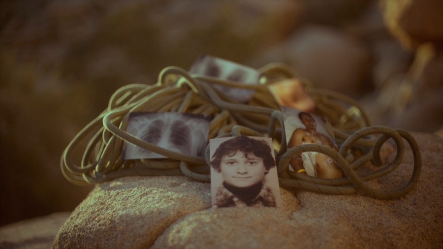 Old photos of Andrea in a coil of rope. Film still.