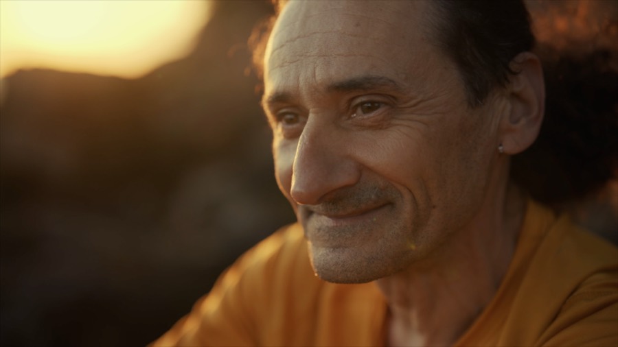 Andrea smiling in late golden light. Film still.