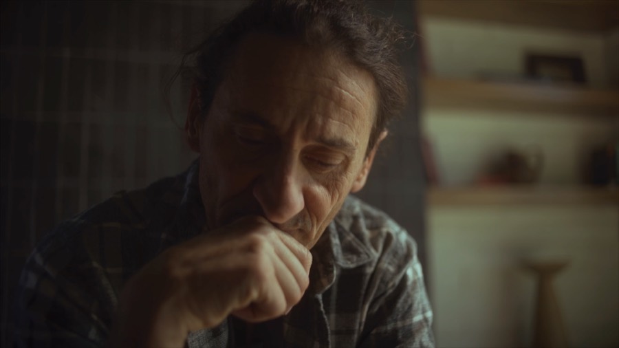 Andrea deep in thought at home. Film still.